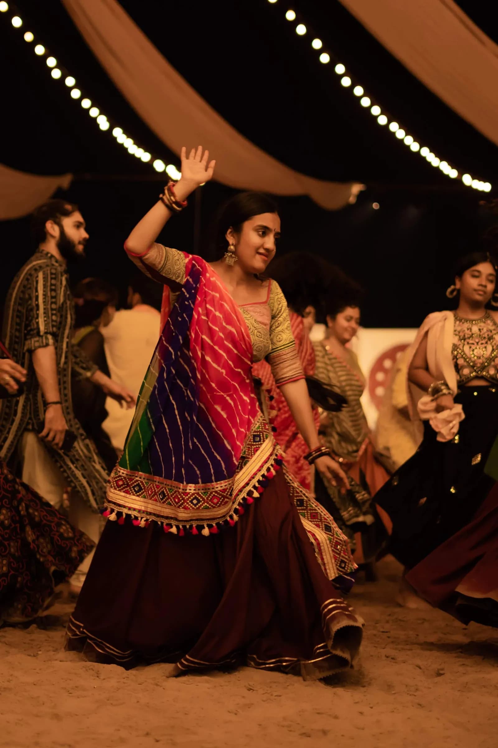 A dancer spinning, skirt flared, under strung lights
