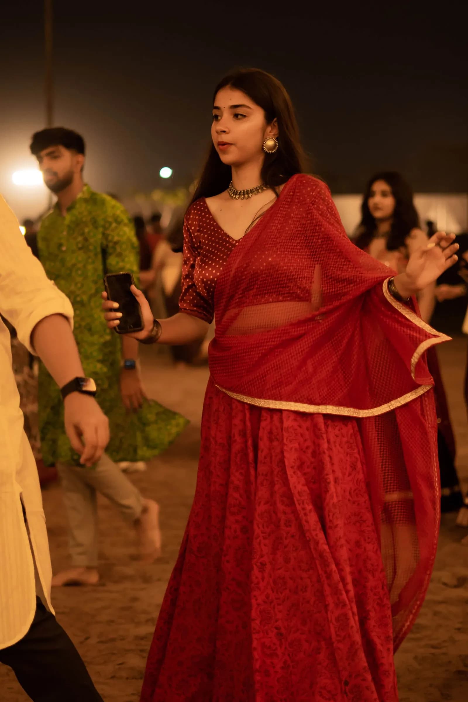A dancer in red crossing the ground