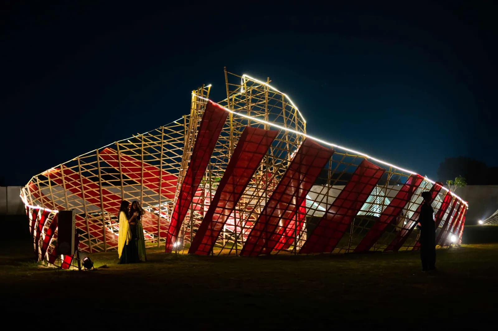 A red and white striped installation lit against the night