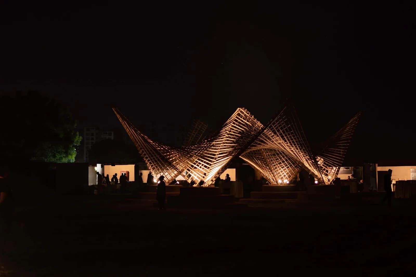 A pale installation lit against the night sky