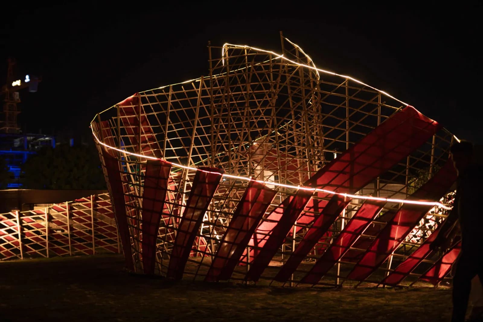 The curved installation frame lit in red and gold