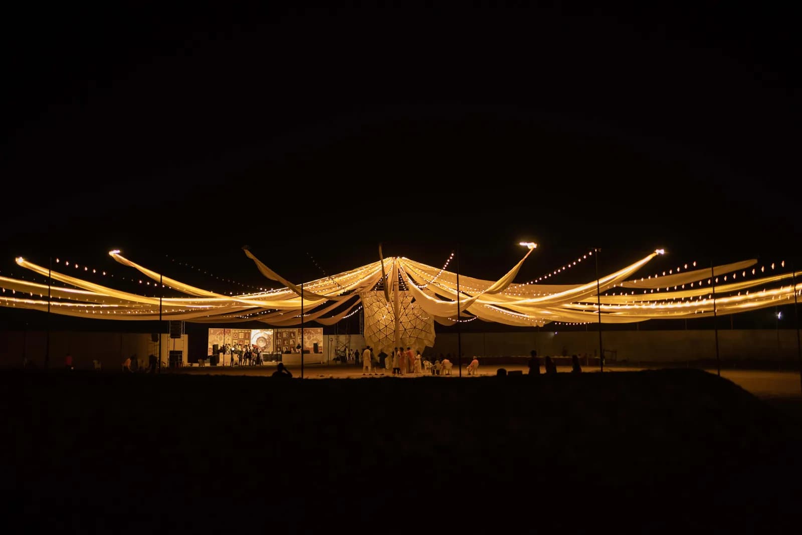 The fabric canopy stretched over the ground at night